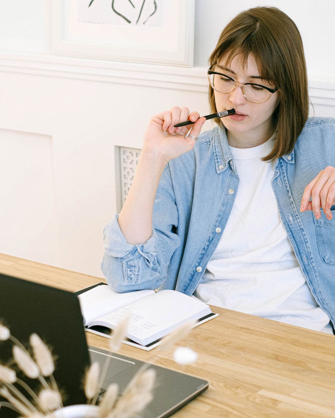 坐在筆電前思考工作的女性